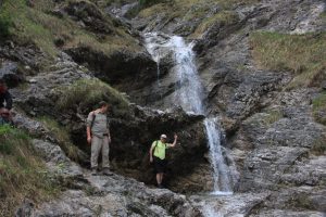 Wanderer am Wasserfall in Wolfsschlucht